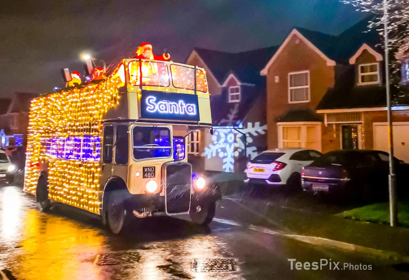 Santa on Wheels bus touring through a Stockton-on-Tees housing estate, with santa waving from the top of the bus.