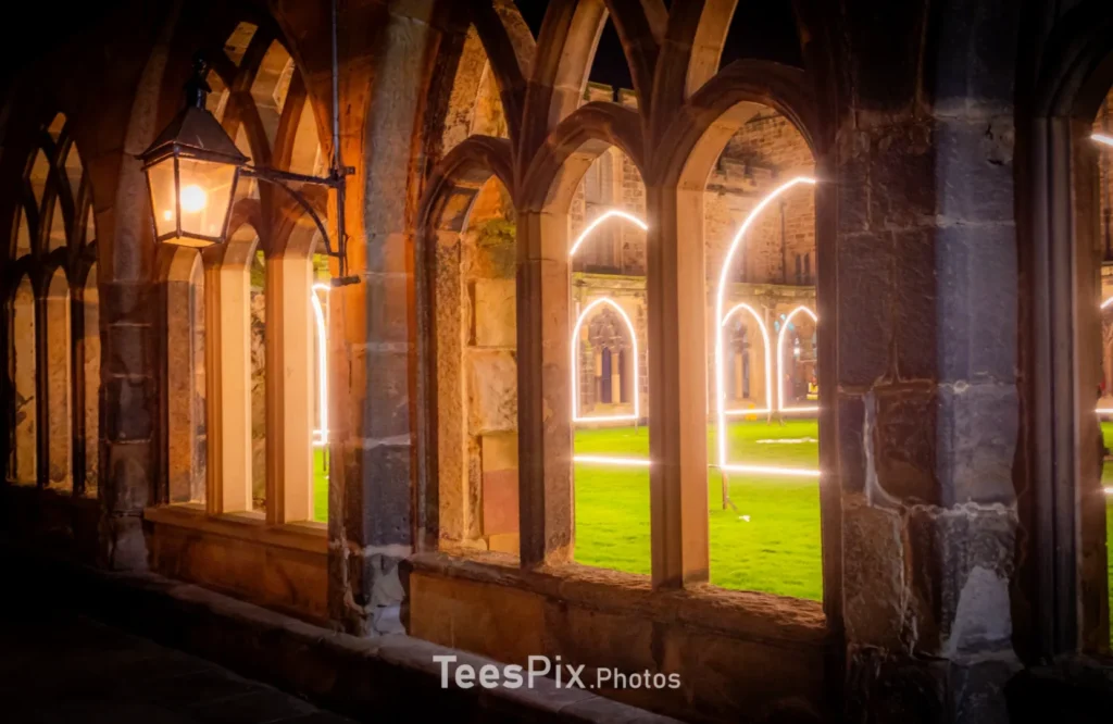 The inner court yard of Durham Catherdral cloisters through an open window showing Adam Frelin's Inner Cloister artwork as part of Lumiere Durham